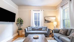 A living room with a sofa, coffee table, and a TV.