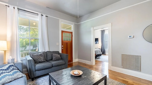 A living room with a sofa, coffee table, and a view through a large window.