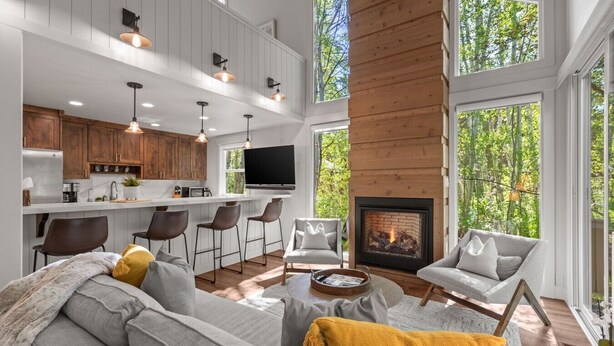 A modern interior with a kitchen, bar area, and seating with a fireplace. - 2 Min Walk To Ski*Hot Tub, Pool, Gym, Modern (Park City)