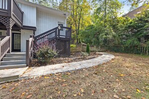 A two-story house with a front porch, a wooden fence, and a pathway leading to the entrance. - Charming Buckhead 1 BR Unit Queen TheraPedic Bed (Atlanta)