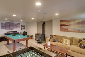 Una mesa de billar, un sofá y obras de arte en un salón.