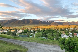 Paisaje rural con montañas, una carretera y casas dispersas.