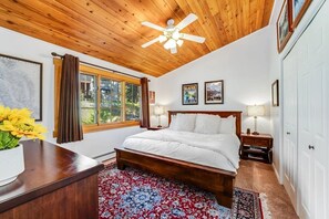 Bedroom featuring an angled wood ceiling, wood bed frame, and large window. - Whitefish Lake Condo w/ Dock & Pool (Whitefish)