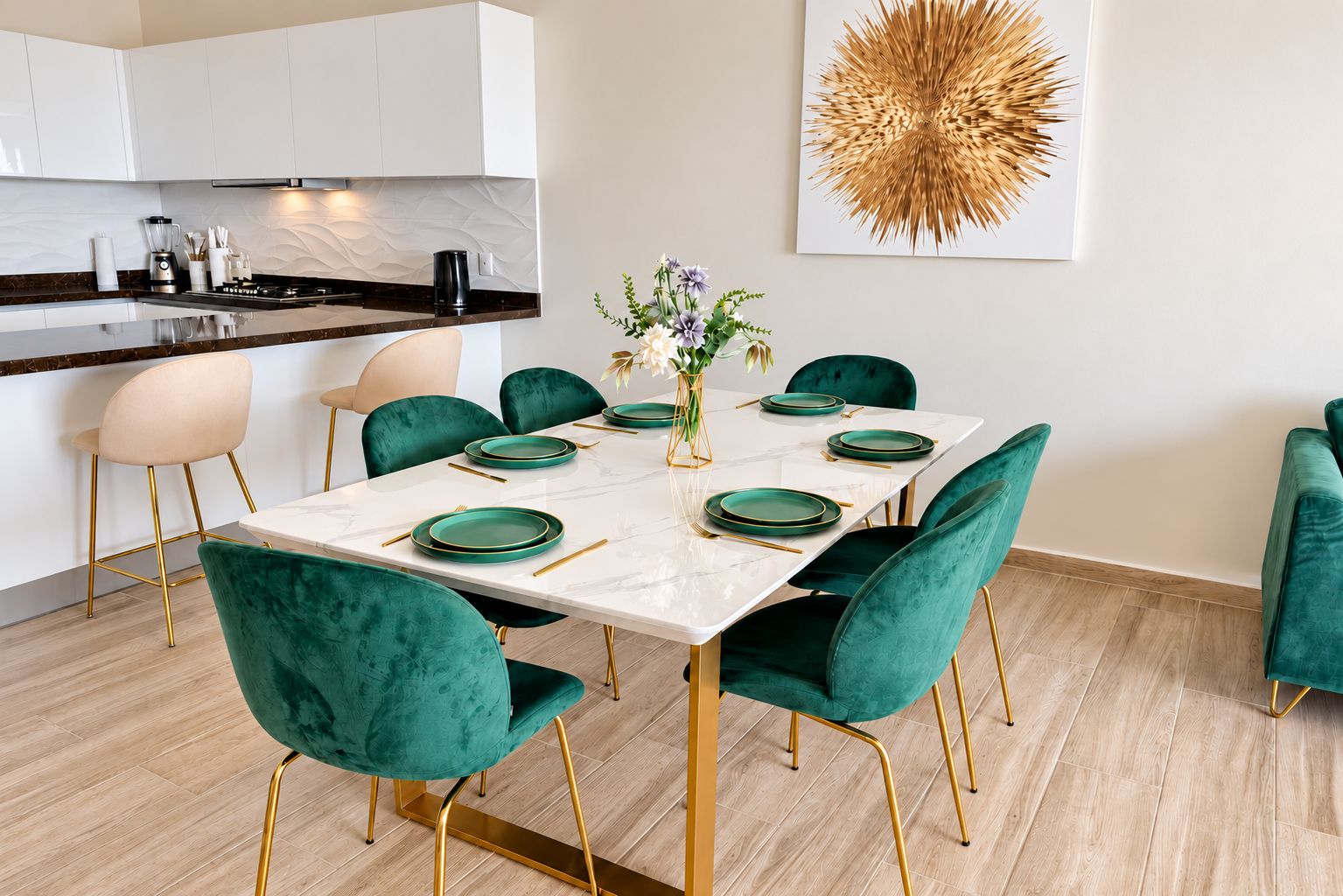A modern dining area with a marble table, teal velvet chairs, and gold accents.