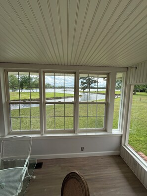 Una habitación con vistas a un lago, una silla y una ventana que da al exterior.
