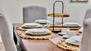 A dining table set with plates, cups, and a candle holder. - 3BR Home Near Outlets & Event Center ,
Pet Friendly, Backyard (Allen)