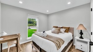 A bedroom with a bed, bedside table, lamp, window, and a desk with chair. - 3BR Home Near Outlets & Event Center ,
Pet Friendly, Backyard (Allen)