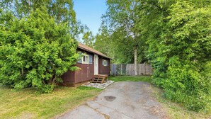 A small wooden cabin with a porch and a wooden fence. - Cozy Anchorage Cabin, Full Kitchen & Deck (Anchorage)