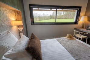 Una camera da letto con un letto, una finestra, una scrivania e una sedia.