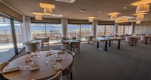 A restaurant with round tables, chairs, and hanging lamps. - Mildiss Hotel BW Signature Collection (Besse-et-Saint-Anastaise)