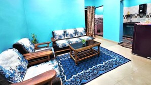 Una sala de estar con sofá, mesa de centro y alfombra estampada.