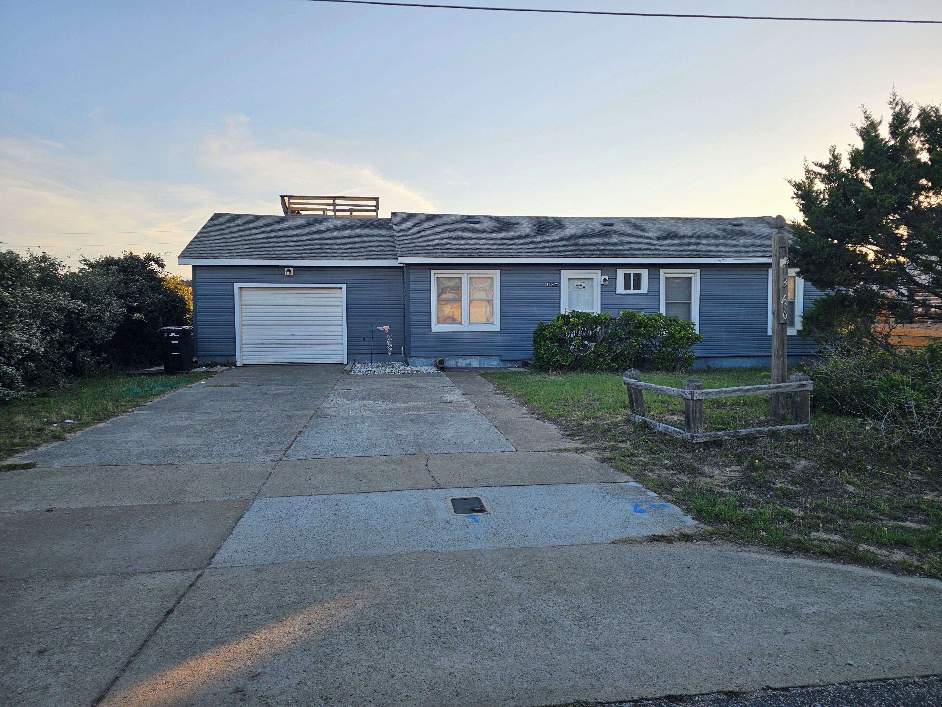 A single-story house with a garage, a small porch, and a front yard.
