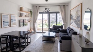 Uma sala de estar moderna com uma mesa de jantar, sofá e obras de arte.