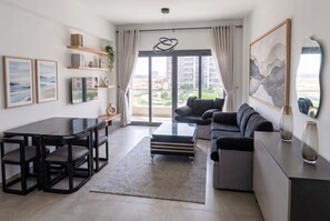 Ein modernes Wohnzimmer mit Esstisch, Sofa und Kunstwerken.