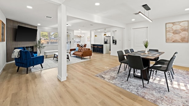 A spacious living area with a blue sofa, a brown sofa, and a dining table with chairs. - Spring Oasis: Heated Pool, Spa • Pickleball • Mini Golf • Basketball • Sleeps 12 (Spring)
