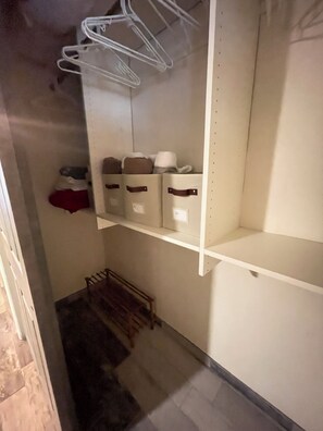 A storage closet with shelves, a drying rack, and hanging clothes. - Cindy's Cozy Casita (Green Valley)