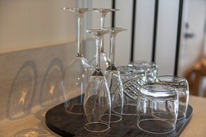A tray with several empty wine glasses and a decorative glass container. - The Stables Motel (Bulls)