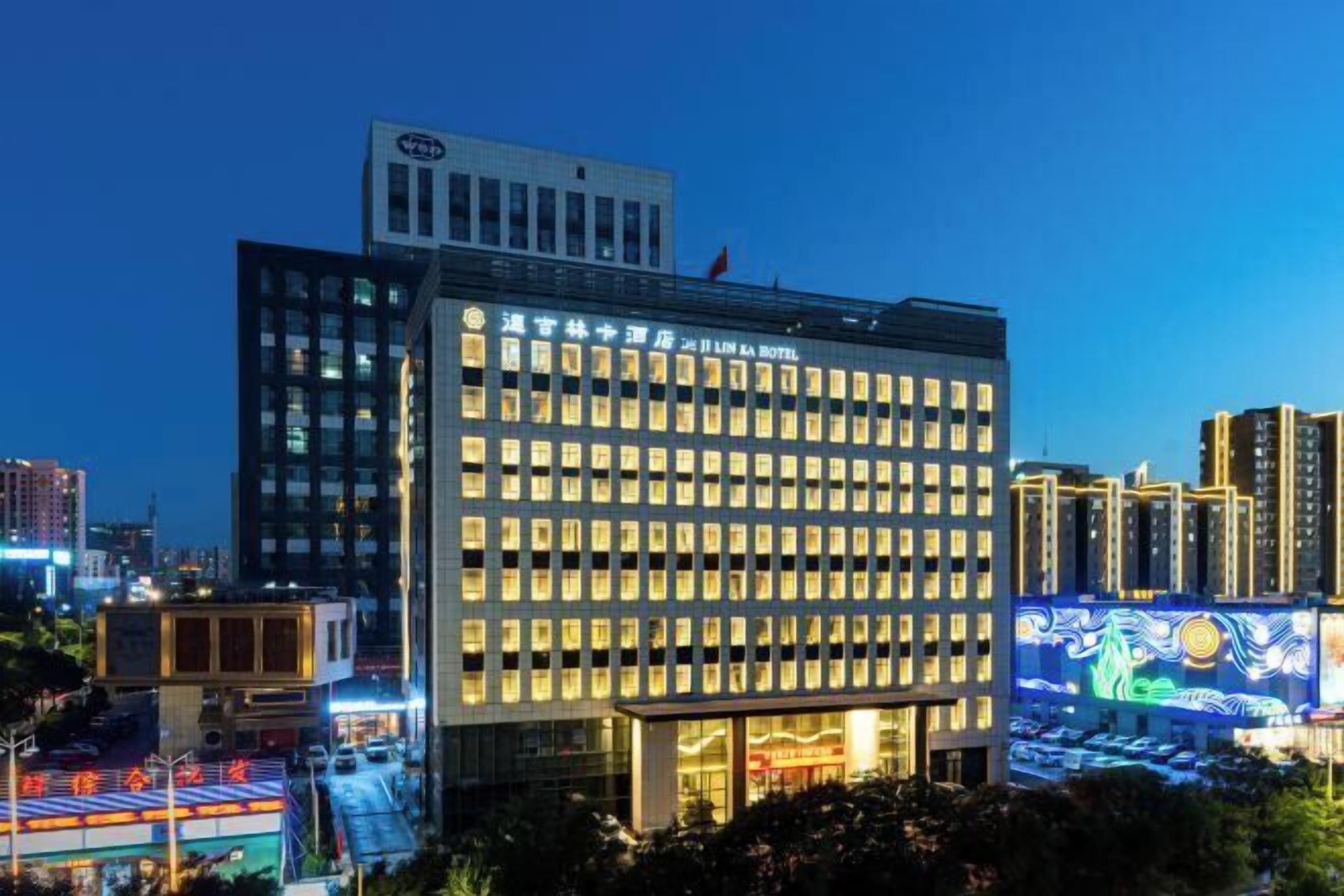 A modern hotel building with illuminated windows and a prominent sign.