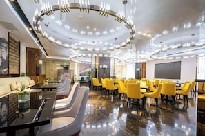 A modern hotel lobby with a central seating area, a bar, and a large screen. - De Ji Lin Ka Hotel (Yinchuan)