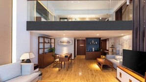 Una sala de estar moderna con un sofá, una mesa de centro, televisor y un comedor con sillas y una mesa.