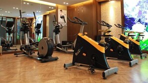 Un gimnasio con bicicletas estáticas, cintas de correr y equipo de ejercicio.