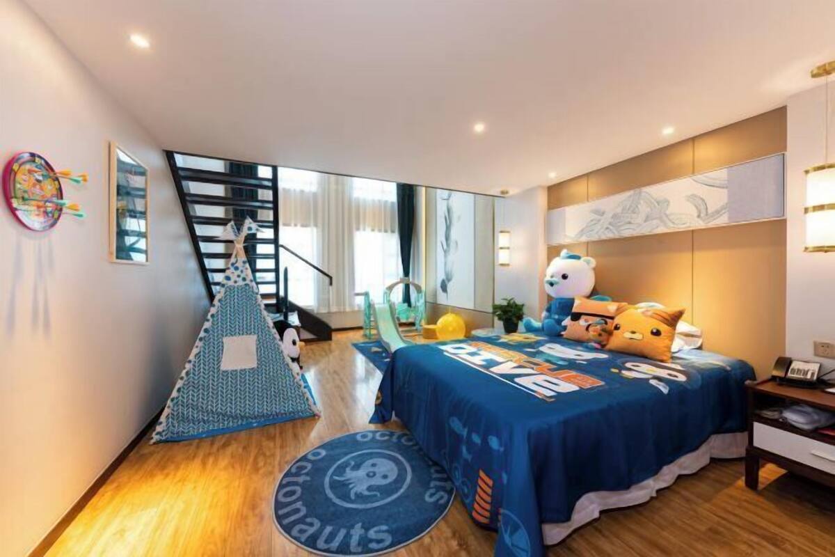 Un dormitorio moderno con cama, almohadas, un escritorio y una ventana.