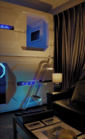 A room with a massage chair, a massage table, a massage lamp, a TV, and a window with curtains. - High Tech Living || Walking Distance City (Carlton)