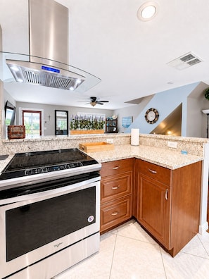 A modern kitchen with a built-in stove, oven, and a wooden cabinet. - Brookside Oasis Leisure Bradenton Stay (Bradenton)