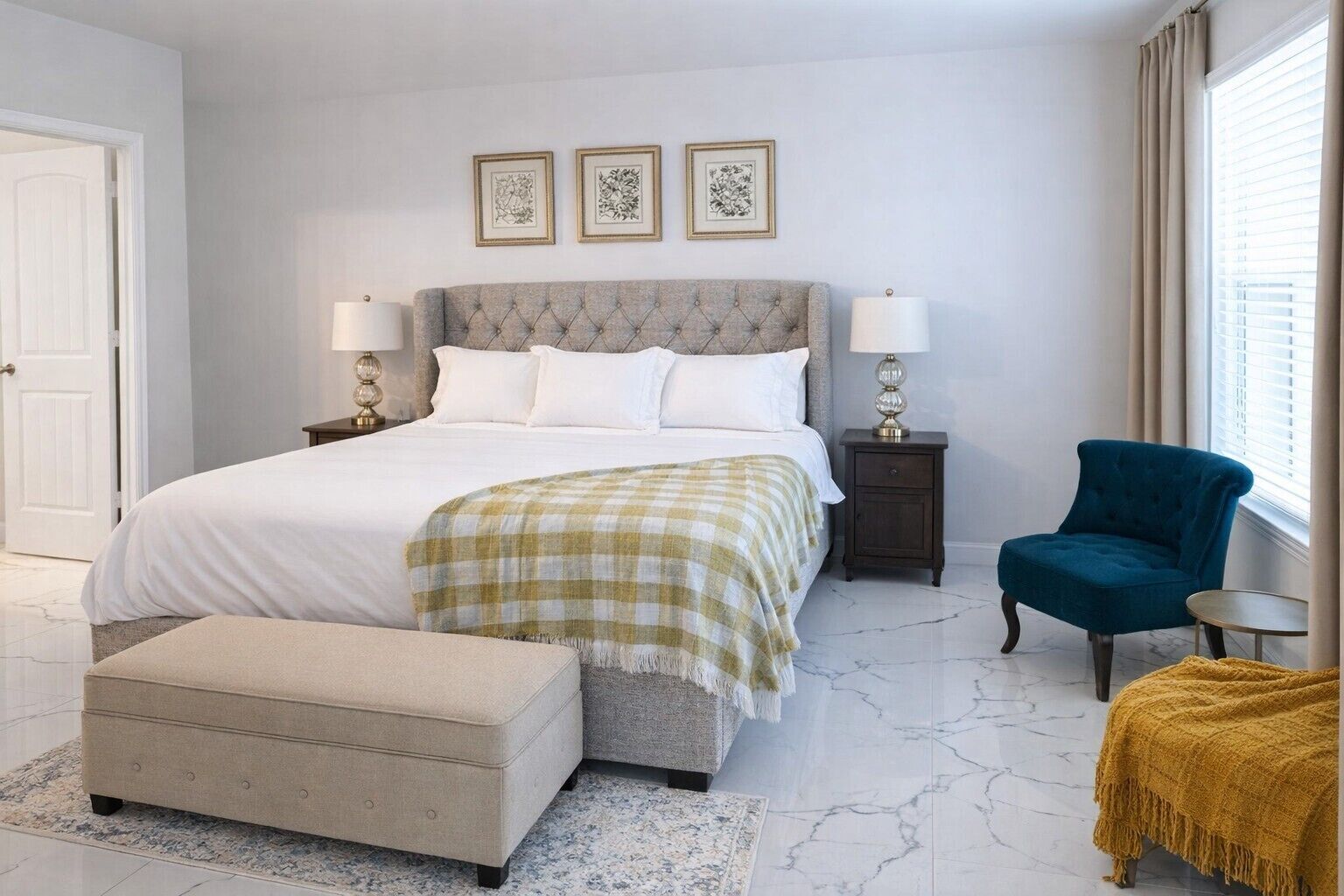 A bedroom with a bed, bedside tables, a chair, and artwork on the wall.