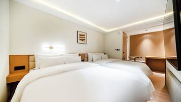 A hotel room with a large bed, bedside tables, a wall-mounted light, and a wooden wardrobe.