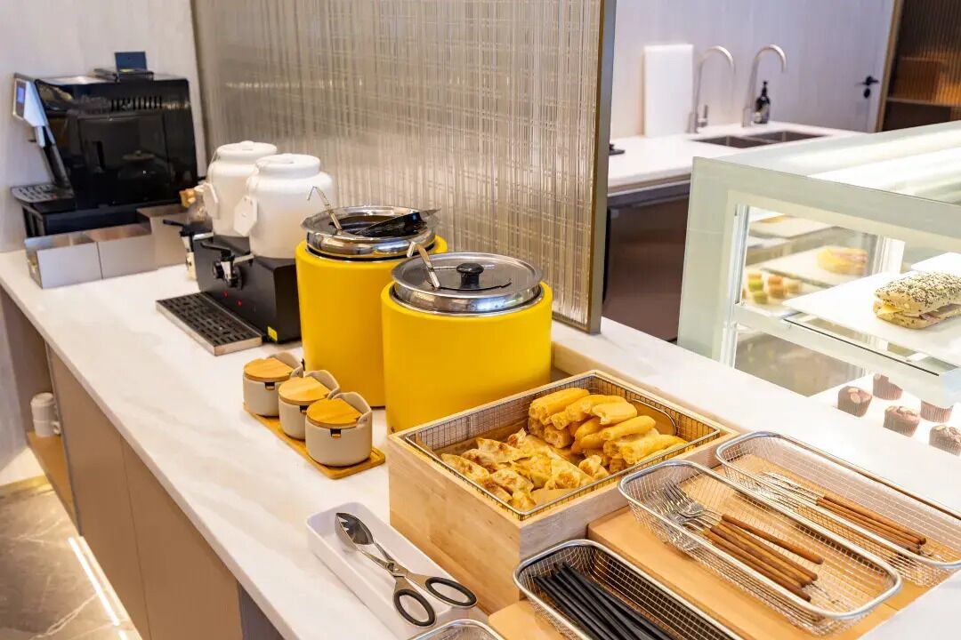 A buffet setup with various food items and utensils.