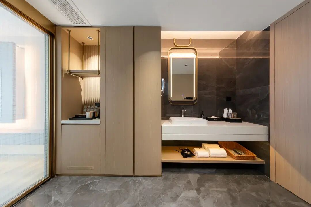 A modern bathroom with a vanity, a mirror, and a shower area.