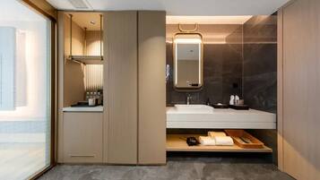 A modern bathroom with a vanity, a mirror, and a shower area.