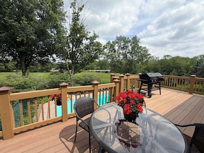 A deck with a glass table, chairs, a barbecue grill, and a pool. - Private Pool Oasis Retreat (Decatur)