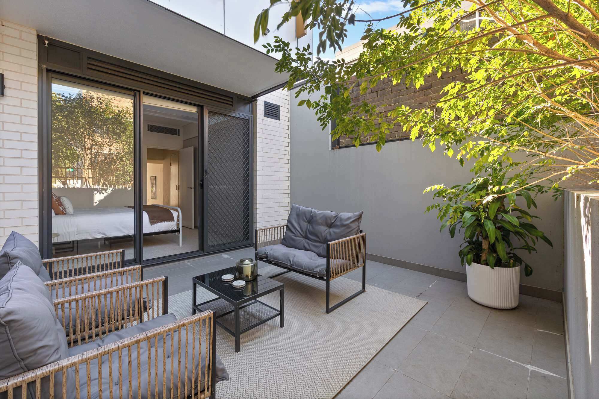 A modern outdoor seating area with a sofa, chairs, and a coffee table.