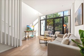 A modern living room with a sofa, a coffee table, and a TV on a wooden stand.