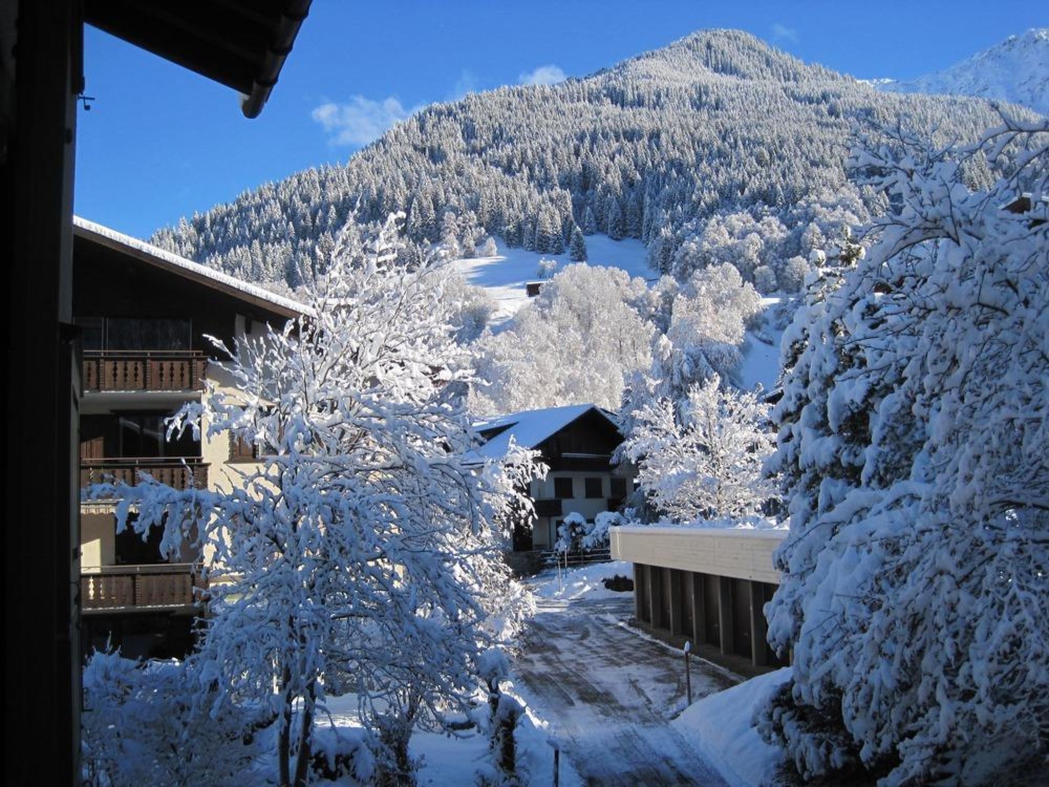 Eine verschneite Berglandschaft mit Gebäuden im Vordergrund.