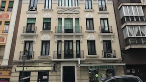 A multi-story building with a pharmacy on the ground floor, balconies, and a classic architectural style. - Atocha VI (Madrid)