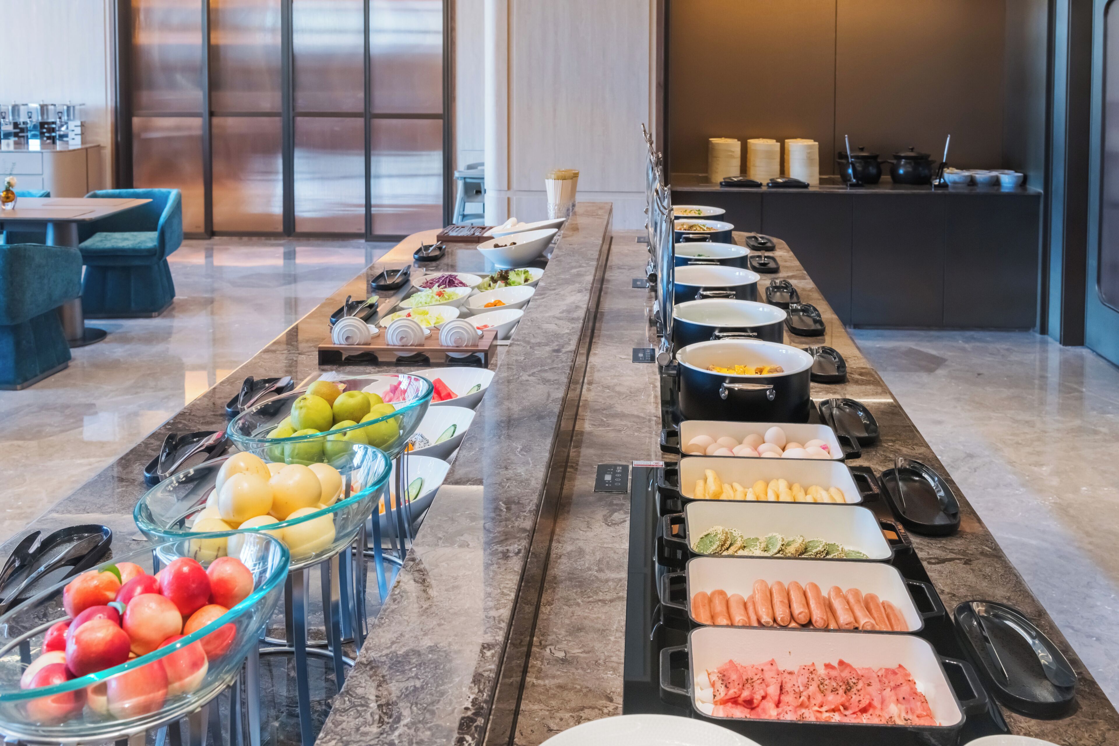 A buffet with various food items and utensils.