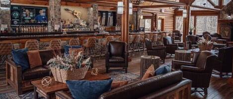 Un interior rústico con muebles de madera, una zona de bar y paredes de piedra.