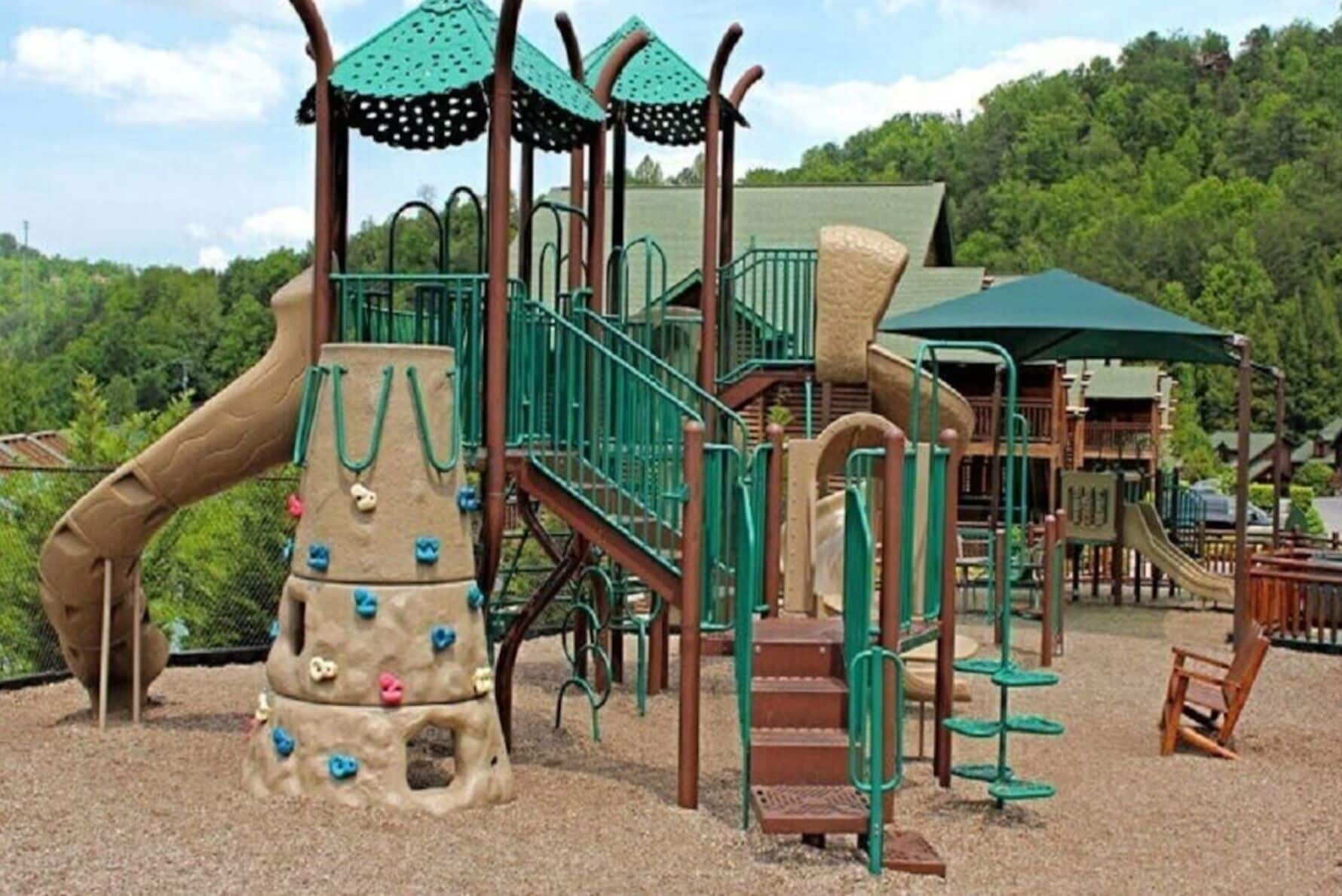 Ein Spielplatz mit Klettergerüsten, Rutschen und einem überdachten Bereich.