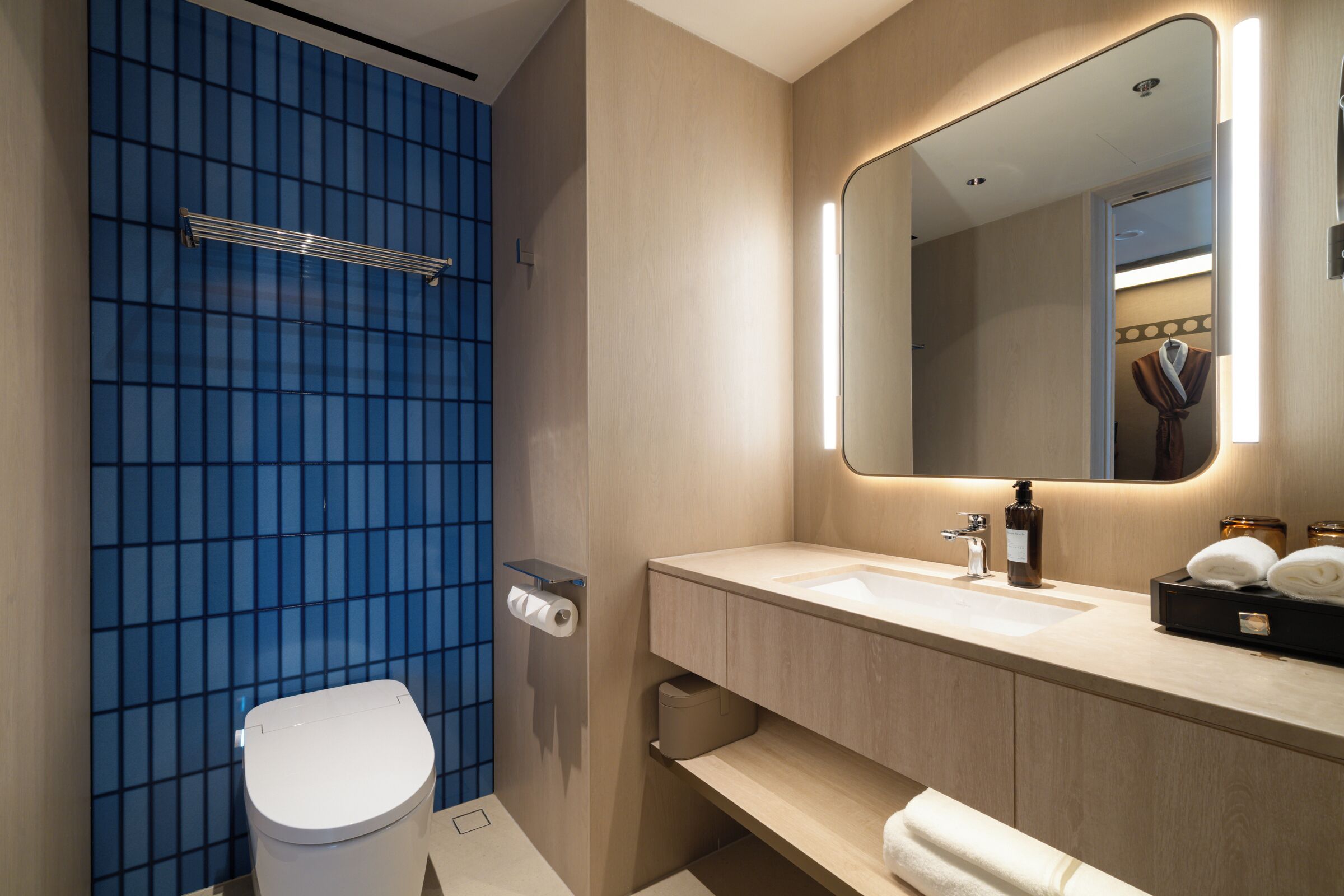 Une salle de bain moderne avec des toilettes, un lavabo et un miroir.