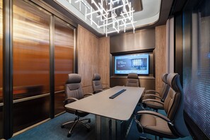 A conference room with a large table, six chairs, a projector screen, and a modern ceiling design.