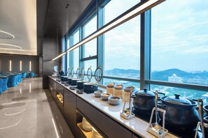 Una cocina moderna con servicio de comidas tipo bufé, ventanas amplias y vista a la ciudad.