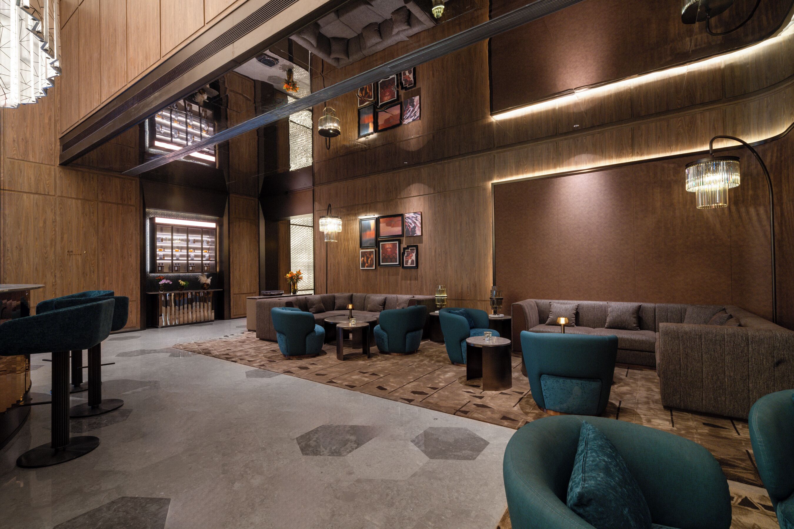 A spacious lobby with a high ceiling, wooden paneling, and a variety of seating options including sofas and chairs.