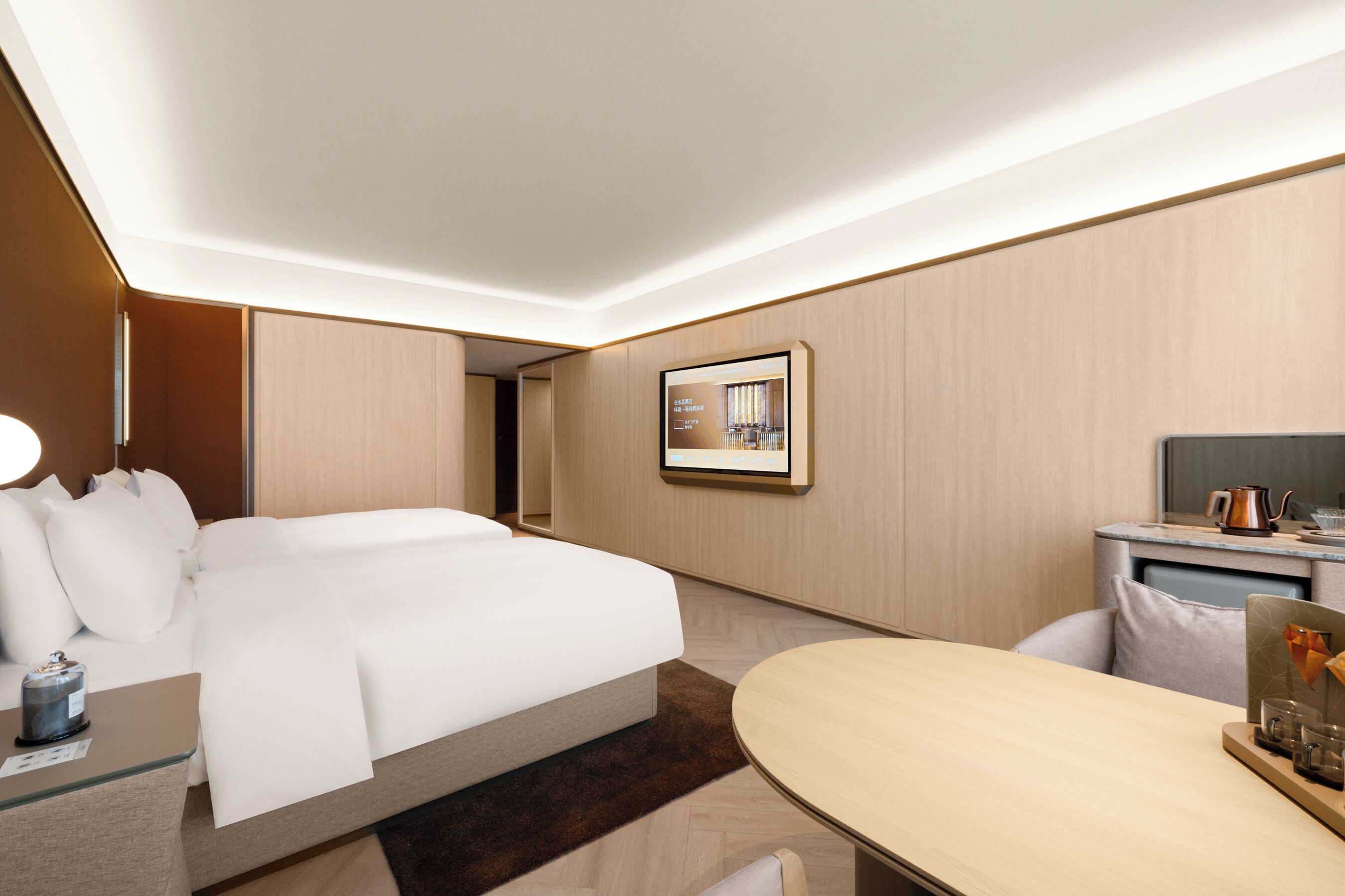 A modern hotel room with a bed, bedside table, and a small desk area.
