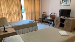 Une chambre d’hôtel avec deux lits, une télévision, un bureau et une chaise.