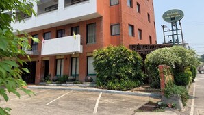Un hôtel avec une enseigne, un parking et des espaces verts.