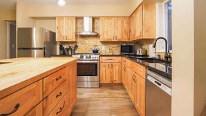 Una cocina moderna con armarios de madera, electrodomésticos de acero inoxidable y una isla grande.