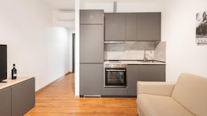 A compact kitchen with grey cabinets, a built-in oven, and a sink. - Ottavia Residence Apartment Silver 3 Pax (Rome)